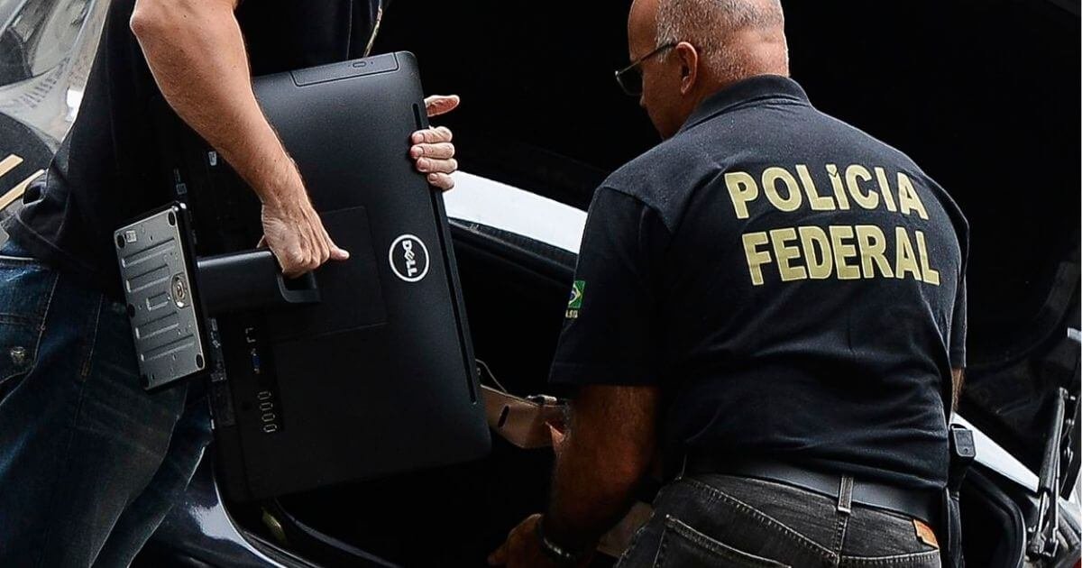 Agente da PF apreendendo computador.